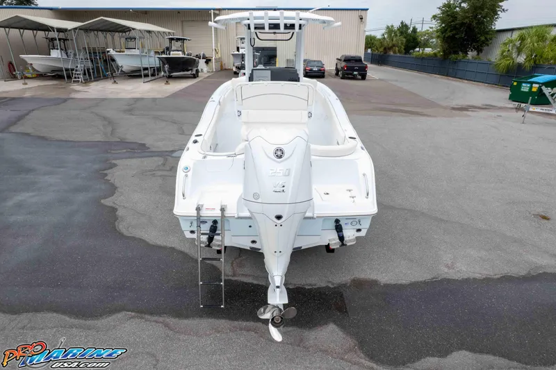 Slide: The Image of 2026 Sea Hunt Ultra 235 SE boat in a marina, rear view with outboard motor. - 17