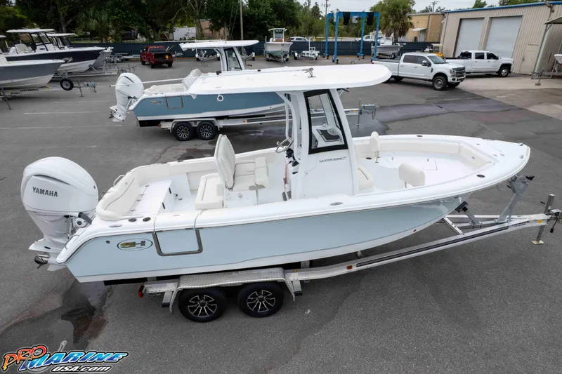 Slide: The Image of 2026 Sea Hunt Ultra 235 SE boat on trailer, featuring Yamaha engine, in a marina setting. - 22