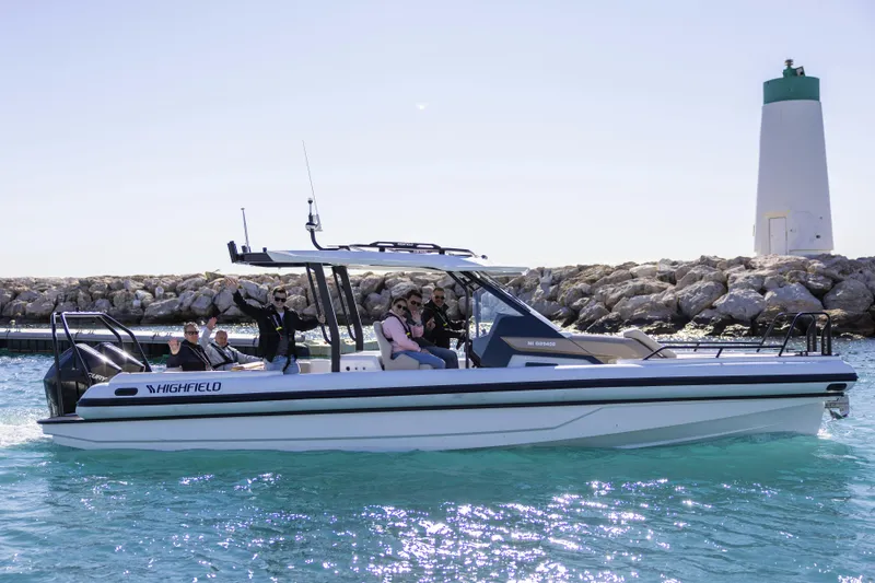 The Image of 2026 Highfield ADV9 boat with passengers near a lighthouse on clear blue water. - 0