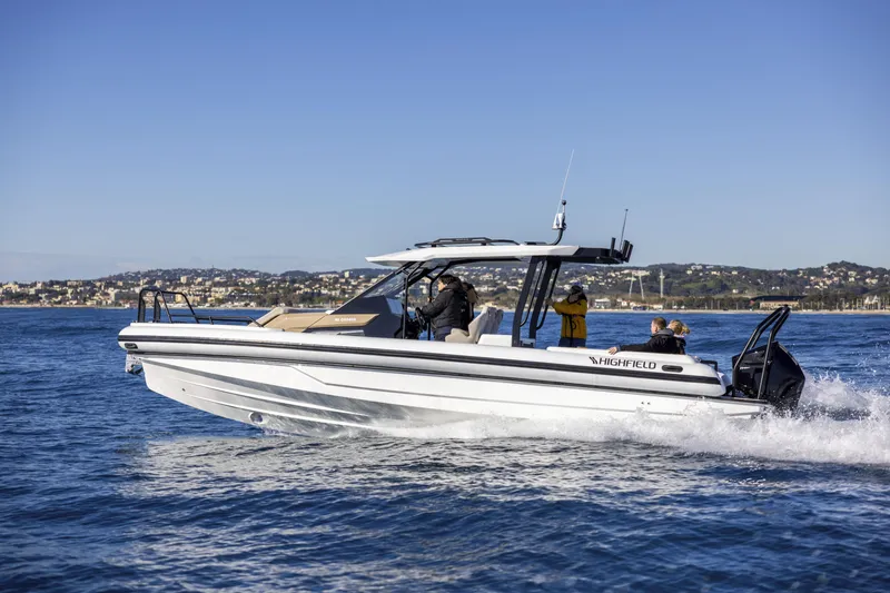 Slide: The Image of 2026 Highfield ADV9 boat cruising on open water with scenic coastal backdrop. - 1