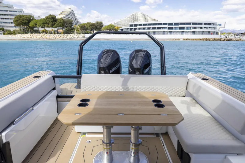 Slide: The Image of 2026 Highfield ADV9 boat interior with seating, table, and dual Mercury engines on a sunny day. - 4