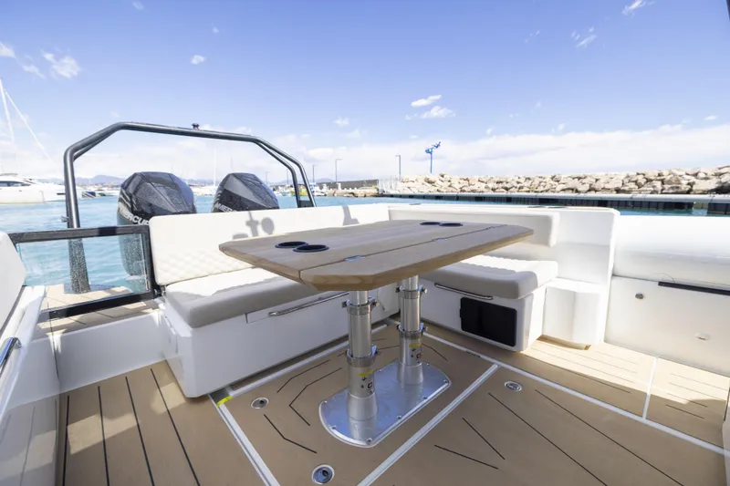 Slide: The Image of 2026 Highfield ADV9 boat interior with seating and table, docked at a marina. - 5