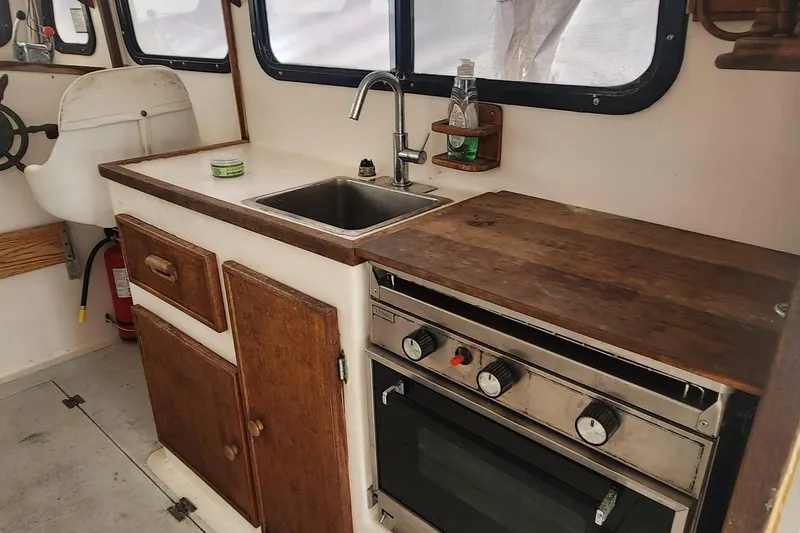 Slide: The Image of 1988 Duffy 31 Lobster Boat interior with sink, stove, and wooden cabinetry. - 10
