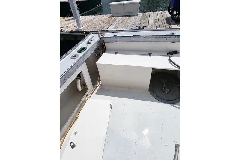 Slide: The Image of 1988 Duffy 31 Lobster Boat deck with storage compartments and dock view. - 19