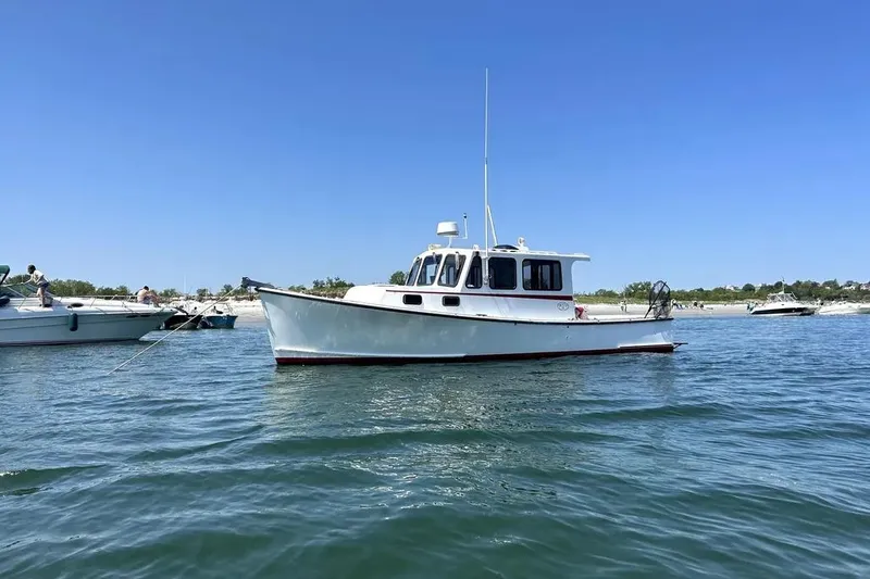 Slide: The Image of 1988 Duffy 31 Lobster Boat on calm water under clear blue sky. - 3