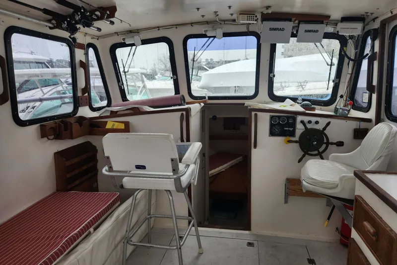 Slide: The Image of Interior of a 1988 Duffy 31 Lobster Boat with steering wheel and seating. - 8