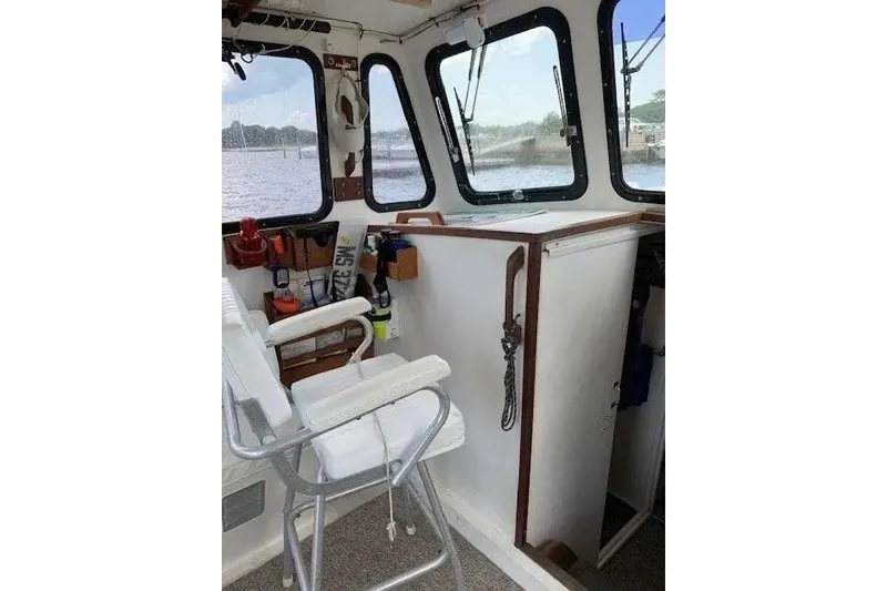 Slide: The Image of Interior of a 1988 Duffy 31 Lobster Boat with helm and seating area. - 9