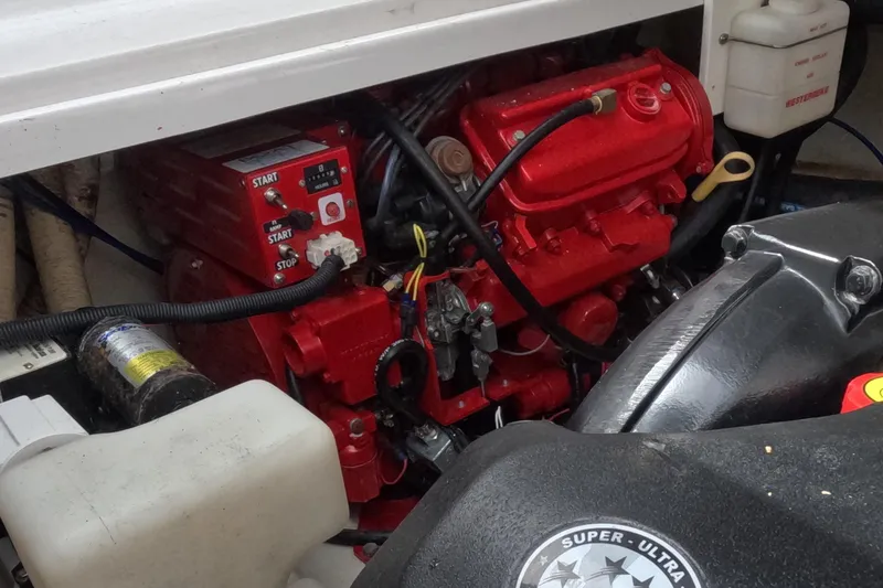 Slide: The Image of Engine compartment of 2012 Four Winns V265 boat, featuring red engine components. - 12