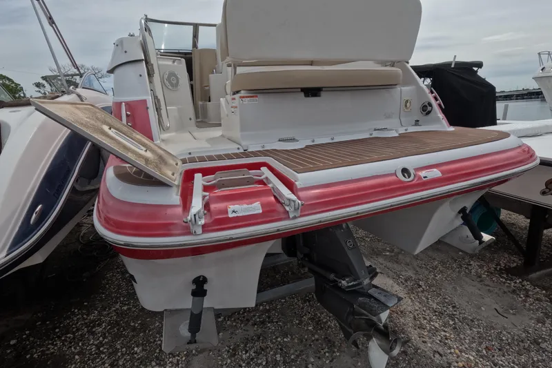Slide: The Image of 2012 Four Winns V265 boat, rear view with open hatch and visible propeller. - 20
