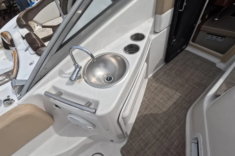 Slide: The Image of 2012 Four Winns V265 boat interior with sink and cup holders. - 32