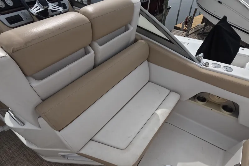 Slide: The Image of 2012 Four Winns V265 boat interior with beige and white seating, steering wheel visible. - 33