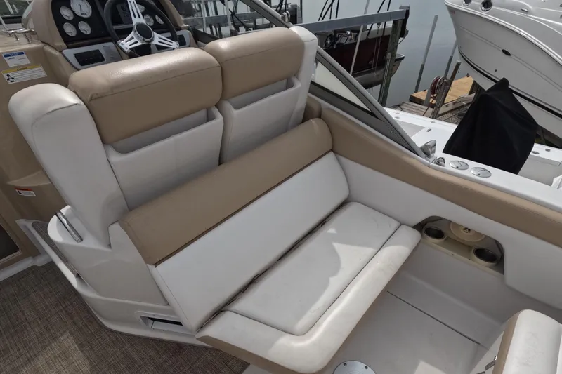 Slide: The Image of 2012 Four Winns V265 boat interior with beige and white seating, steering wheel, and dashboard. - 34