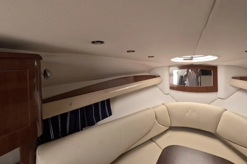 Slide: The Image of Interior of 2012 Four Winns V265 boat with beige seating and wood accents. - 56
