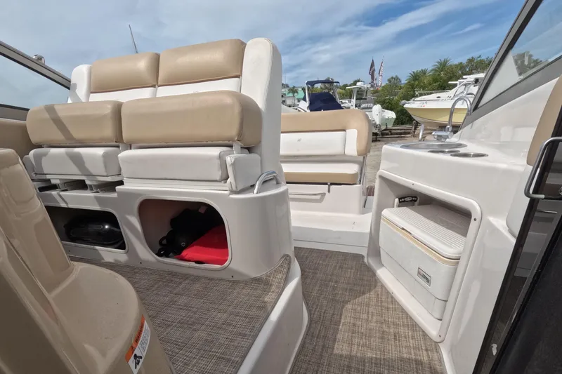 Slide: The Image of 2012 Four Winns V265 boat interior with beige seating and storage compartments. - 64