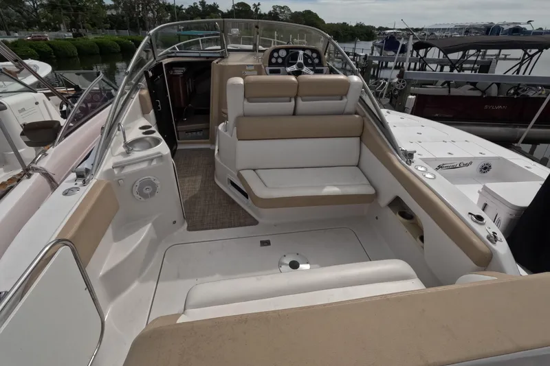 Slide: The Image of 2012 Four Winns V265 boat interior with seating and helm, docked at marina. - 7