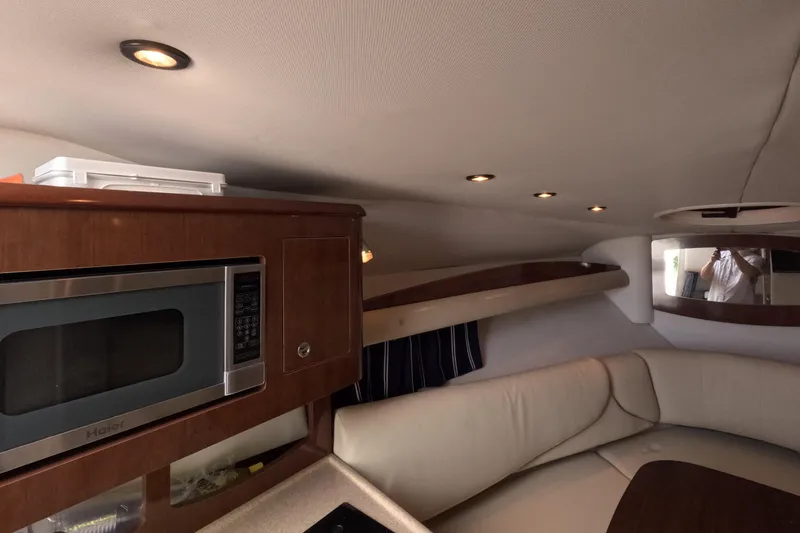 Slide: The Image of Interior of 2012 Four Winns V265 boat with microwave and seating area. - 80