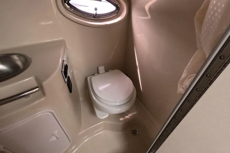 Slide: The Image of 2012 Four Winns V265 boat bathroom with toilet, sink, and porthole window. - 9