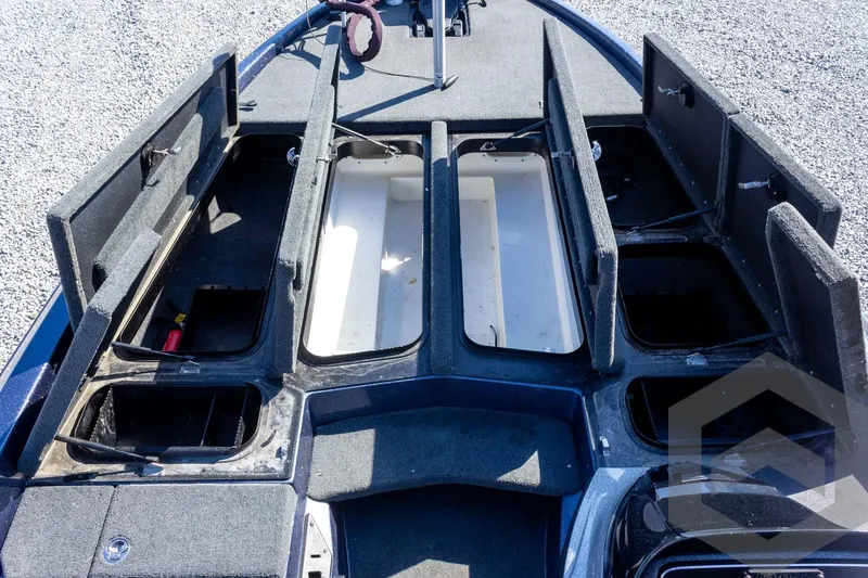 Slide: The Image of 2018 Skeeter ZX250 boat storage compartments open on gravel surface. - 22