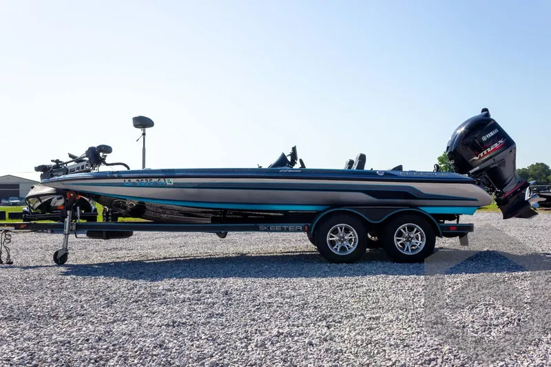 Slide: The Image of 2018 Skeeter ZX250 boat on trailer with Yamaha outboard motor, parked on gravel. - 9