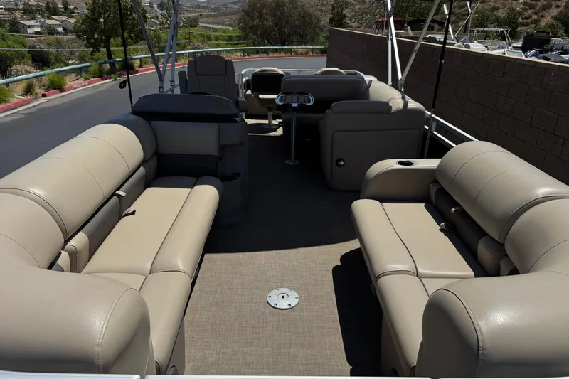 Slide: The Image of 2024 Sun Tracker SportFish 22 DLX pontoon boat with beige seating and spacious deck. - 10