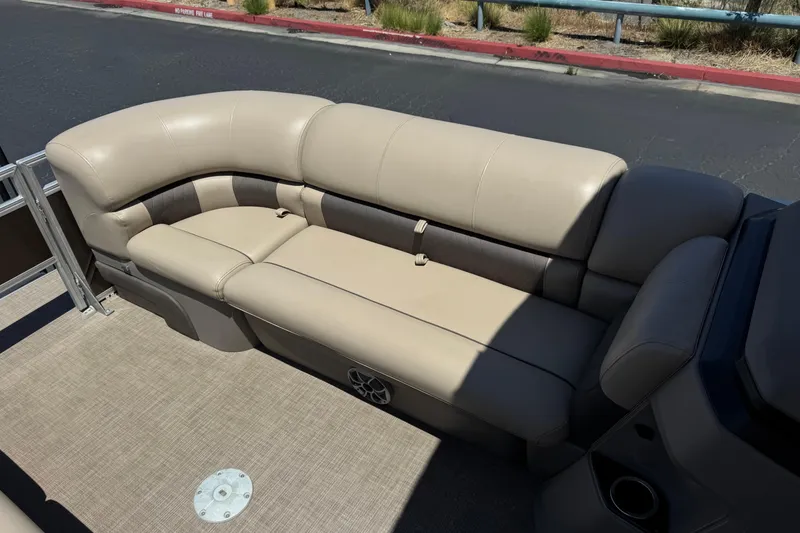 Slide: The Image of 2024 Sun Tracker SportFish 22 DLX pontoon boat with beige seating and carpeted deck. - 14