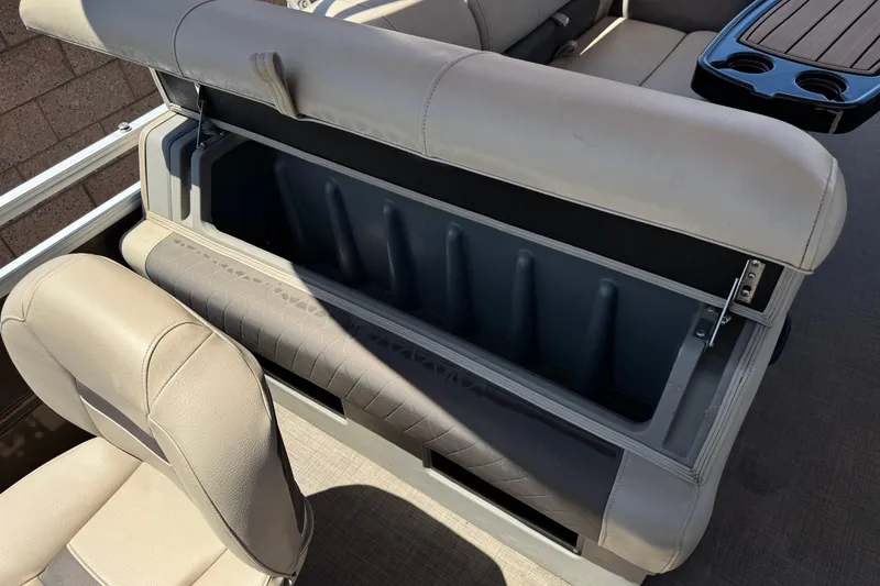 Slide: The Image of 2024 Sun Tracker SportFish 22 DLX boat seat storage compartment open, showcasing interior space. - 23
