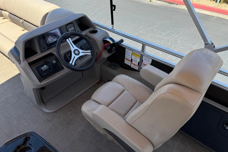 Slide: The Image of 2024 Sun Tracker SportFish 22 DLX boat interior with steering wheel and captain's chair. - 27