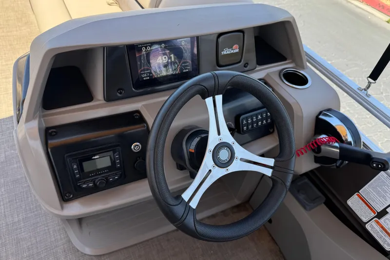 Slide: The Image of 2024 Sun Tracker SportFish 22 DLX dashboard with steering wheel and control panel. - 29