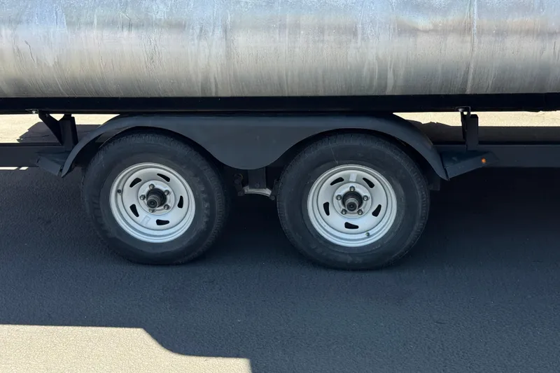 Slide: The Image of Trailer wheels of a 2024 Sun Tracker SportFish 22 DLX on pavement. - 32