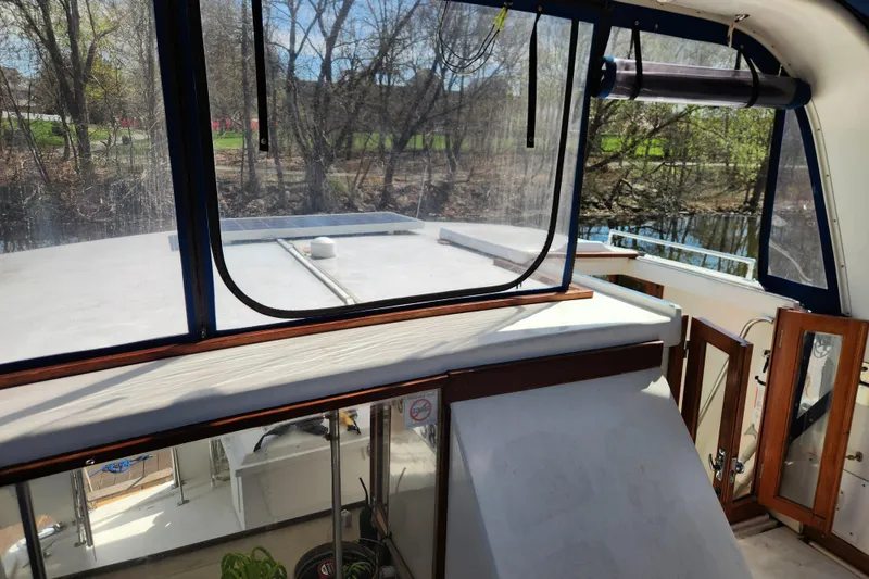 Slide: The Image of 1987 Jefferson 42 SE Sundeck Motor Yacht interior with clear windows and wooden accents. - 10