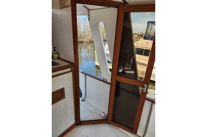 Slide: The Image of 1987 Jefferson 42 SE Sundeck Motor Yacht interior with open door and water view. - 16