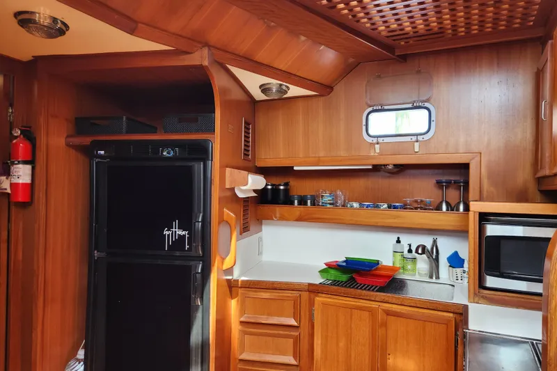 Slide: The Image of 1987 Jefferson 42 SE Sundeck Motor Yacht kitchen with wood cabinetry and modern appliances. - 21