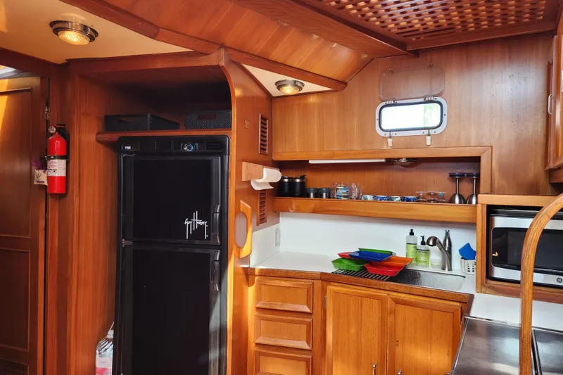 Slide: The Image of 1987 Jefferson 42 SE Sundeck Motor Yacht kitchen with wood cabinetry and modern appliances. - 32