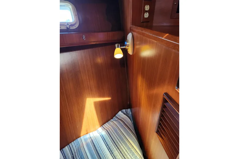 Slide: The Image of Cozy cabin interior of 1987 Jefferson 42 SE Sundeck Motor Yacht with wood paneling and striped bedding. - 34