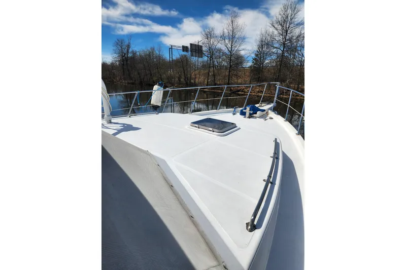 Slide: The Image of 1987 Jefferson 42 SE Sundeck Motor Yacht deck view, surrounded by trees and calm water. - 5