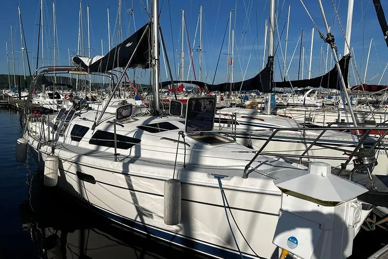 The Image of 2001 Marlow-Hunter 320 sailboat docked in a marina under clear blue skies. - 1