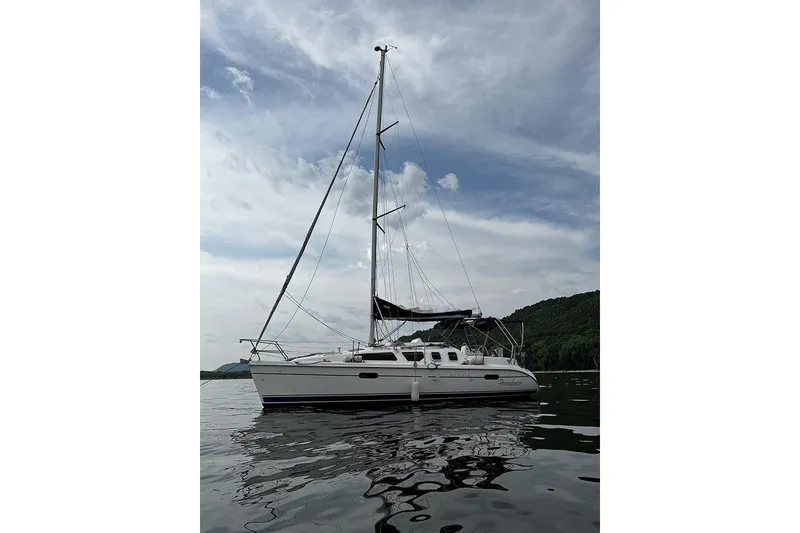Slide: The Image of Sailboat Marlow-Hunter 320, 2001 model, on calm water under a cloudy sky. - 11