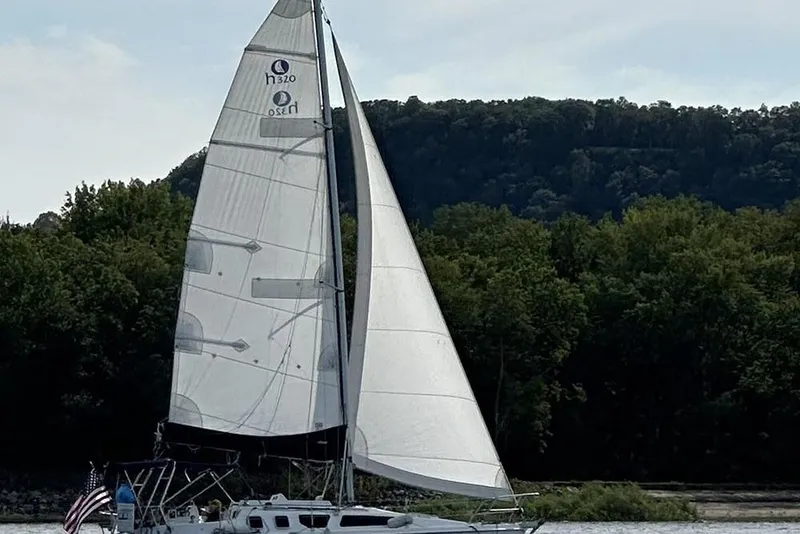 Slide: The Image of Sailboat Marlow-Hunter 320 (2001) cruising on a lake with forested hills in the background. - 12
