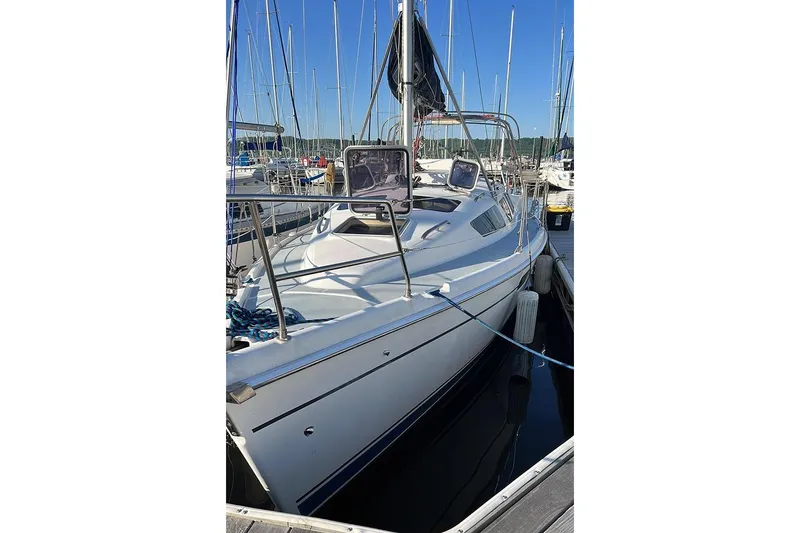 Slide: The Image of 2001 Marlow-Hunter 320 sailboat docked at marina, clear sky background. - 13