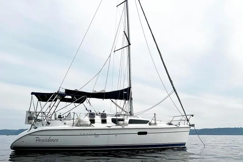 Slide: The Image of 2001 Marlow-Hunter 320 sailboat on calm water, featuring sleek design and white hull. - 4