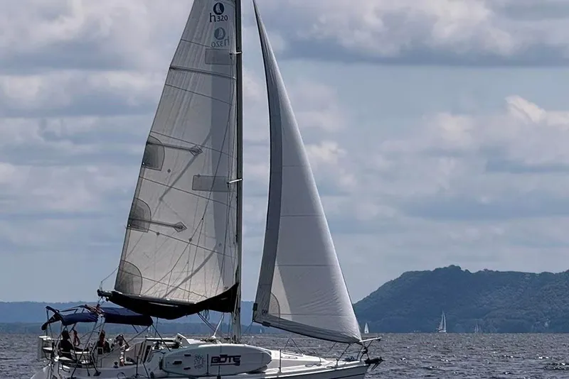 Slide: The Image of Sailing yacht Marlow-Hunter 320, 2001 model, cruising on a calm sea with distant hills. - 5