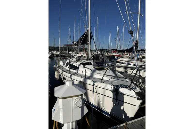 Slide: The Image of 2001 Marlow-Hunter 320 sailboat docked at a marina under clear blue skies. - 6