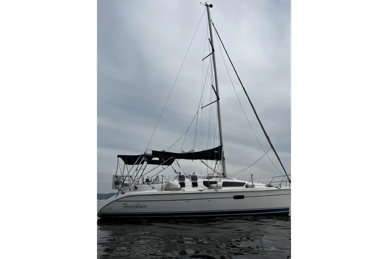 Slide: The Image of 2001 Marlow-Hunter 320 sailboat on calm water under cloudy skies. - 8