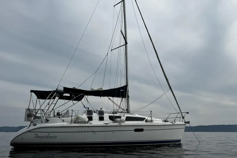 Slide: The Image of 2001 Marlow-Hunter 320 sailboat named "Providence" on calm waters under cloudy skies. - 9