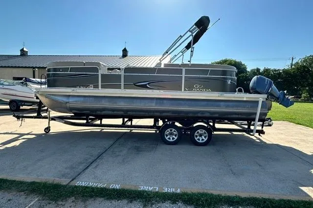 Slide: The Image of 2014 Veranda Relax V2275RC pontoon boat on trailer, parked outdoors. - 2