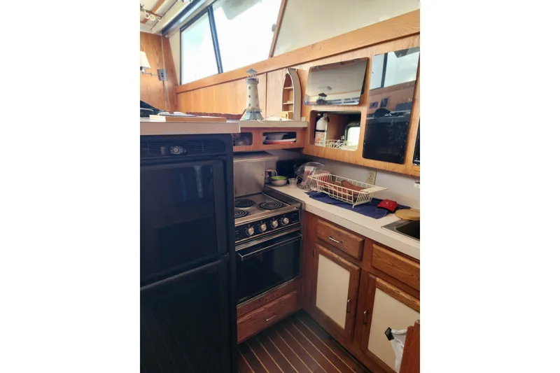 Slide: The Image of 1987 Luhrs 40 Convertible yacht kitchen with stove, cabinets, and countertop. - 13