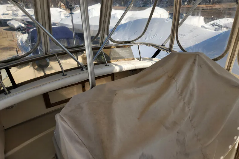 Slide: The Image of 1987 Luhrs 40 Convertible boat interior with covered controls and marina view. - 15