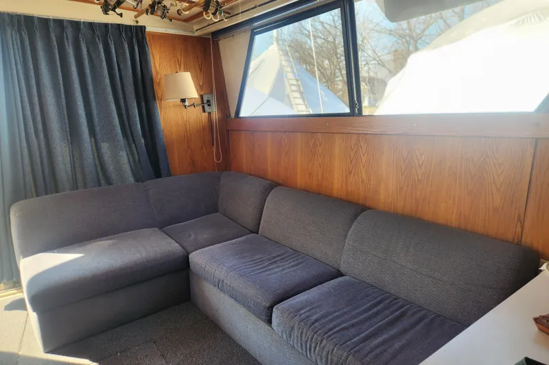Slide: The Image of Interior of 1987 Luhrs 40 Convertible with gray sectional sofa and wood paneling. - 21