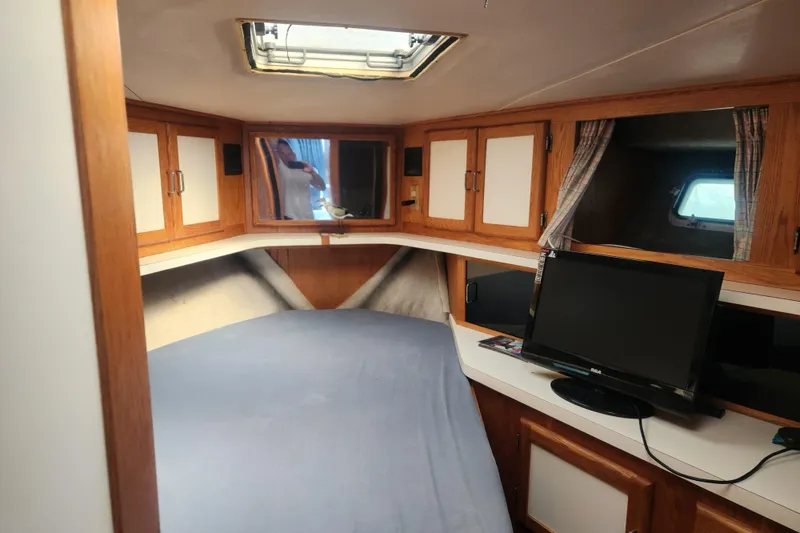 Slide: The Image of Interior of 1987 Luhrs 40 Convertible boat with bed, cabinets, and TV. - 23