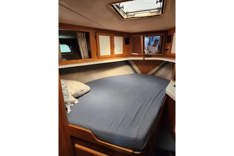 Slide: The Image of Cozy cabin interior of 1987 Luhrs 40 Convertible yacht with bed and wooden cabinetry. - 28